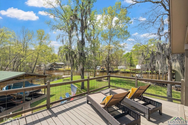 wooden terrace with a yard and a water view