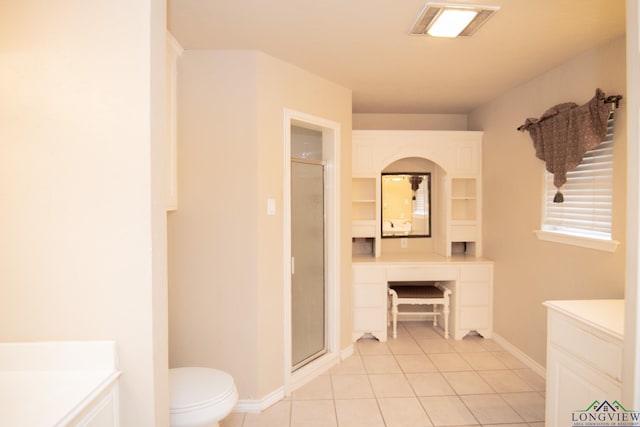 bathroom featuring tile patterned flooring, toilet, an enclosed shower, and vanity