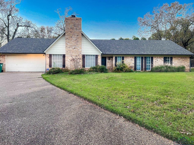 single story home featuring a garage and a front yard