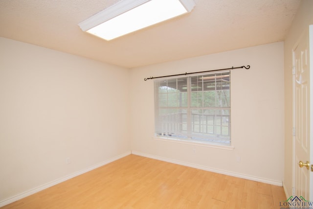 empty room featuring hardwood / wood-style flooring and a textured ceiling