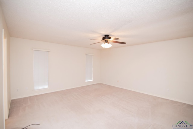 unfurnished room featuring light carpet, a textured ceiling, and ceiling fan