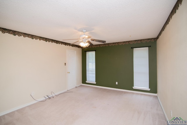 carpeted empty room featuring ceiling fan and a textured ceiling