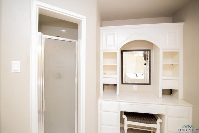 bathroom with built in shelves and walk in shower