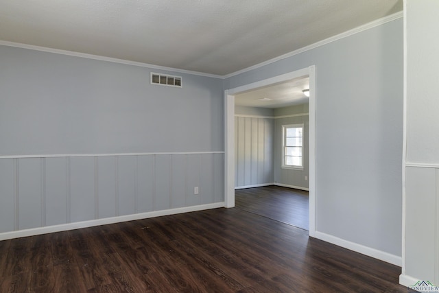 empty room featuring dark hardwood / wood-style flooring and ornamental molding