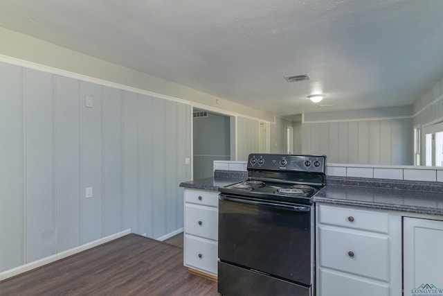 kitchen with dark hardwood / wood-style floors, black electric range oven, and white cabinetry