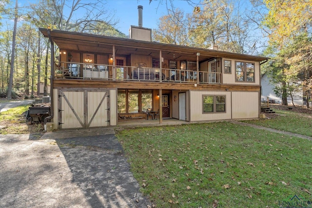 rear view of house featuring a yard