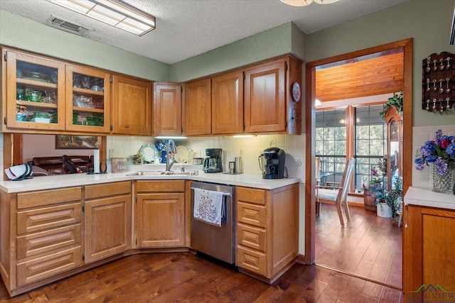 kitchen with decorative backsplash, dark wood-type flooring, stainless steel dishwasher, and sink