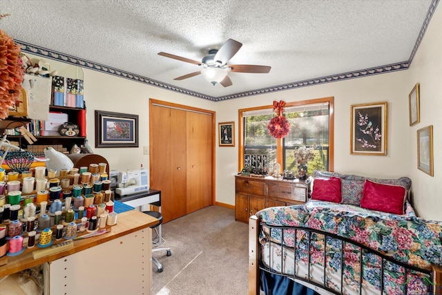 bedroom featuring ceiling fan, a closet, light carpet, and a textured ceiling