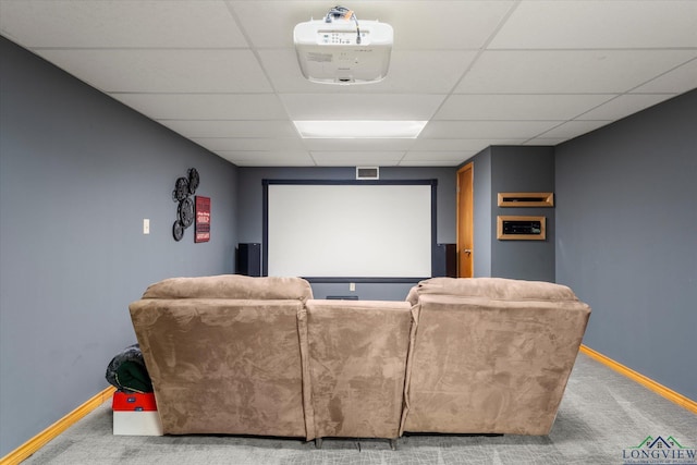 carpeted cinema room featuring a paneled ceiling