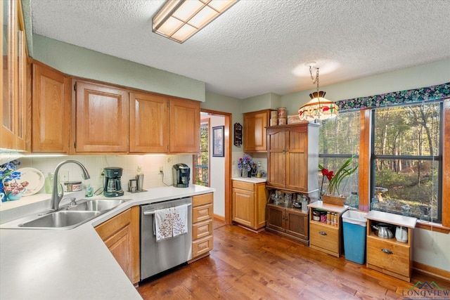 kitchen featuring sink, stainless steel dishwasher, dark hardwood / wood-style floors, backsplash, and decorative light fixtures