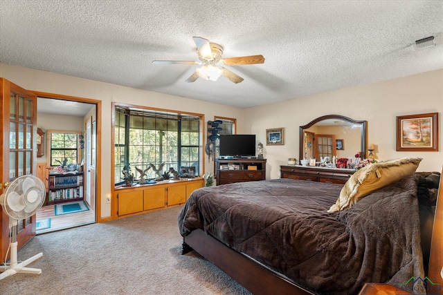 carpeted bedroom with a textured ceiling and ceiling fan