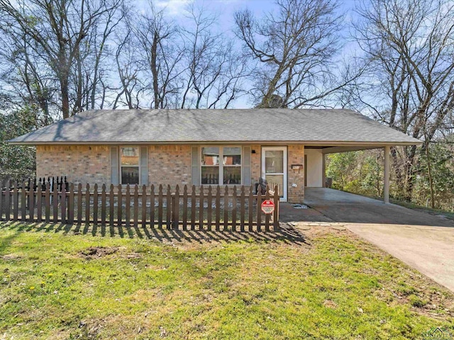 view of front of home featuring a fenced front yard, driveway, a carport, and a shingled roof