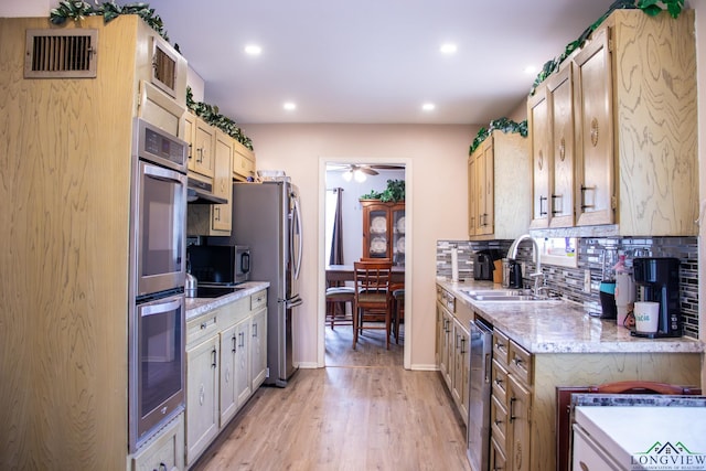1508 Miami Dr, Longview, TX 75601 - kitchen with a sink, stainless steel appliances, decorative backsplash, ceiling fan, and light wood-type flooring