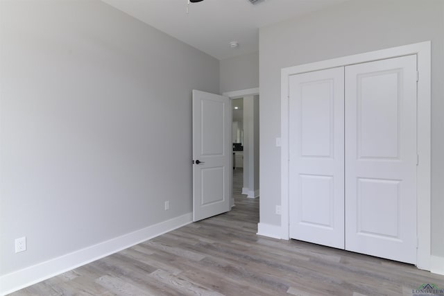 unfurnished bedroom featuring light wood-type flooring and a closet