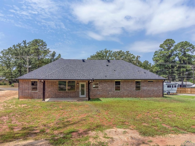 rear view of house featuring a yard and a patio