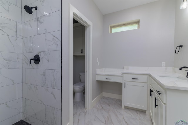 bathroom with vanity, toilet, and a tile shower