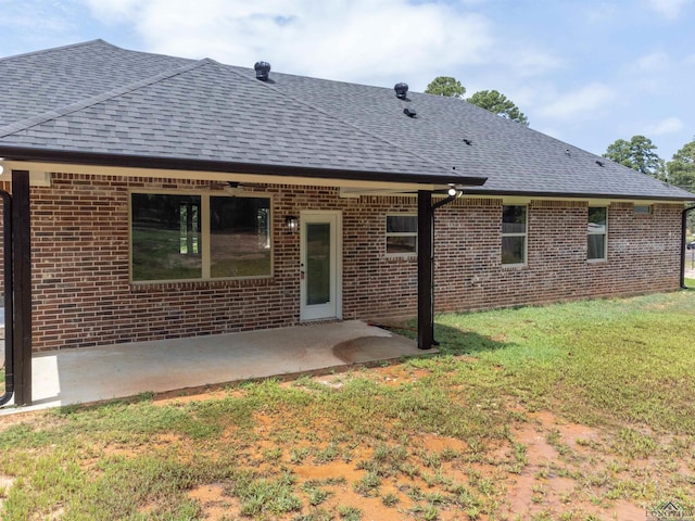 back of property with a patio area and a yard