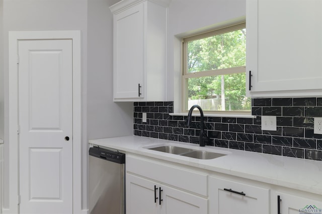 kitchen featuring backsplash, dishwasher, white cabinetry, and sink