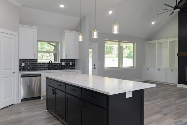 kitchen with backsplash, stainless steel dishwasher, white cabinets, a center island, and hanging light fixtures