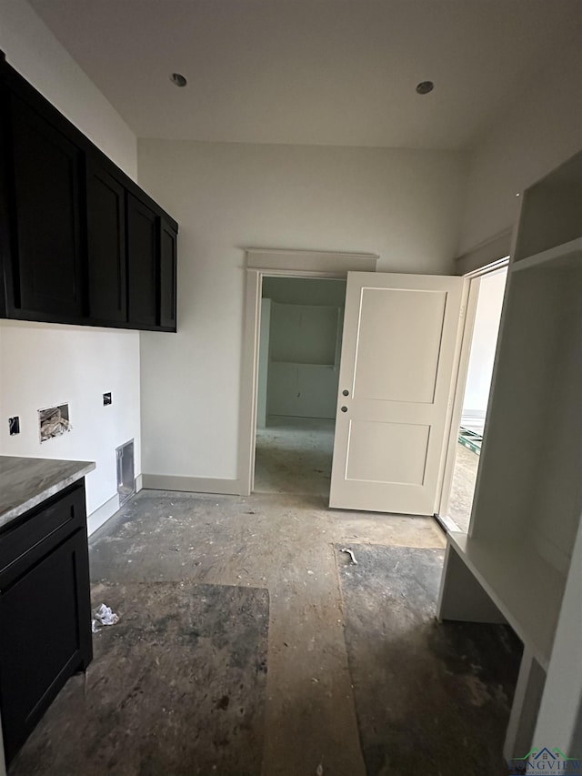 clothes washing area with cabinets