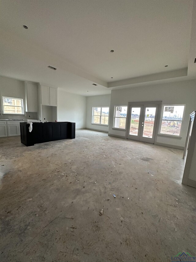 unfurnished living room featuring a tray ceiling