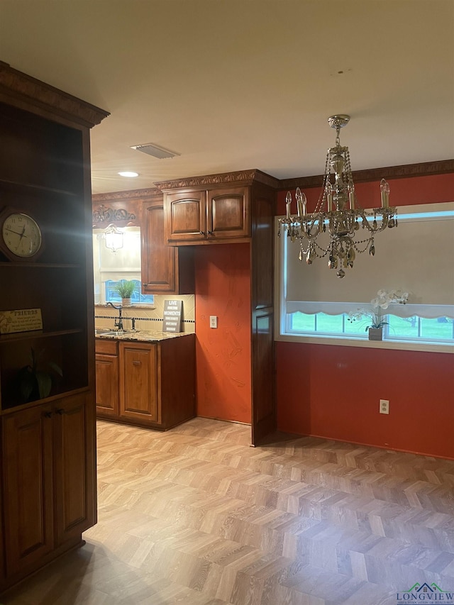 201 Mockingbird Ln, Longview, TX 75601 - kitchen with a chandelier, brown cabinetry, and light stone countertops