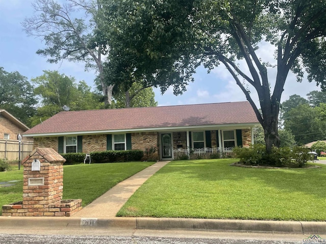 201 Mockingbird Ln, Longview, TX 75601 - ranch-style house featuring a front yard, covered porch, brick siding, and a shingled roof