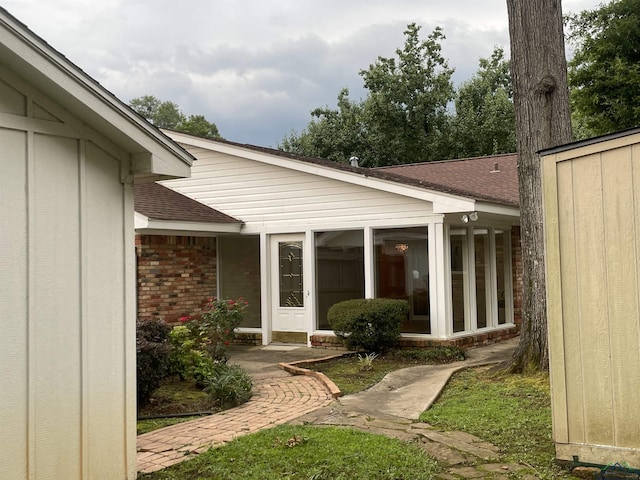 201 Mockingbird Ln, Longview, TX 75601 - rear view of property with a sunroom, brick siding, and roof with shingles