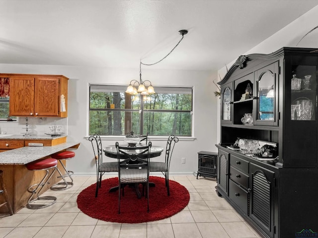 dining area featuring light tile patterned floors and an inviting chandelier