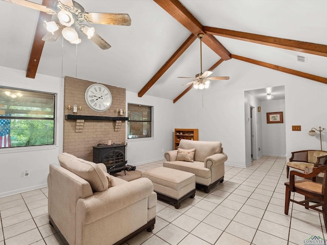 living room with vaulted ceiling with beams, a wood stove, ceiling fan, and light tile patterned flooring