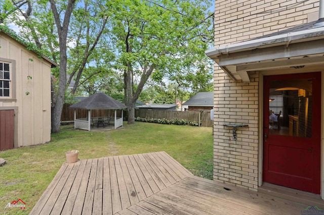 deck with a lawn, a gazebo, and a fenced backyard