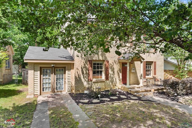 view of front facade with brick siding and fence
