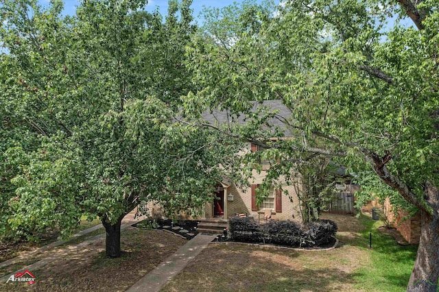 view of front of home with fence, a front lawn, and brick siding