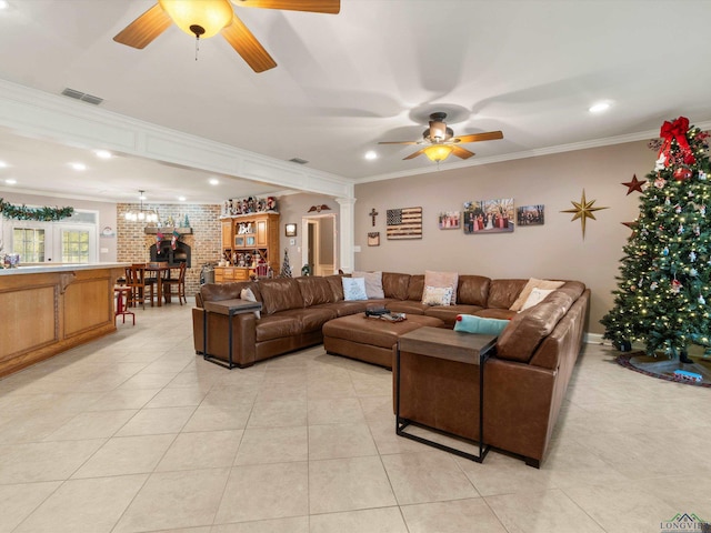 tiled living room with ornate columns, ceiling fan, brick wall, and ornamental molding