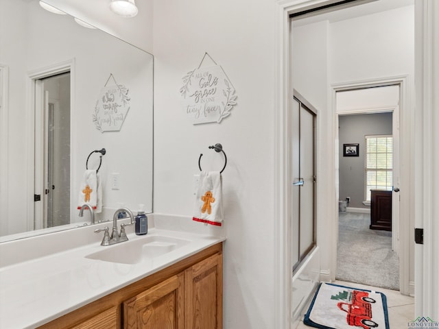 bathroom with tile patterned floors, vanity, and shower / bath combination with glass door