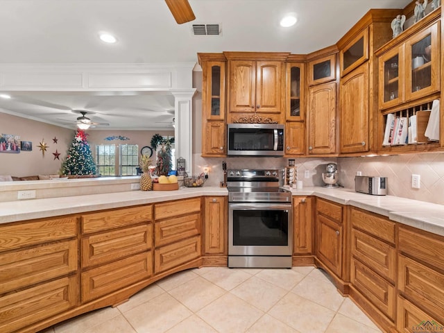 kitchen featuring stainless steel appliances, tasteful backsplash, light tile patterned floors, and ceiling fan