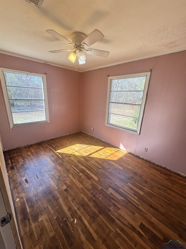 unfurnished room featuring crown molding, dark hardwood / wood-style floors, and a healthy amount of sunlight