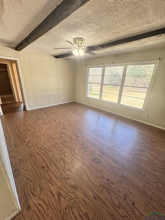 unfurnished room with beam ceiling, dark wood-type flooring, a textured ceiling, and ceiling fan