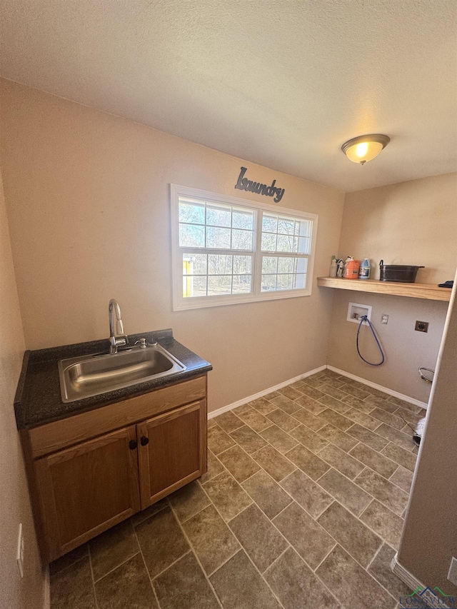 laundry room with cabinets, washer hookup, sink, and a textured ceiling