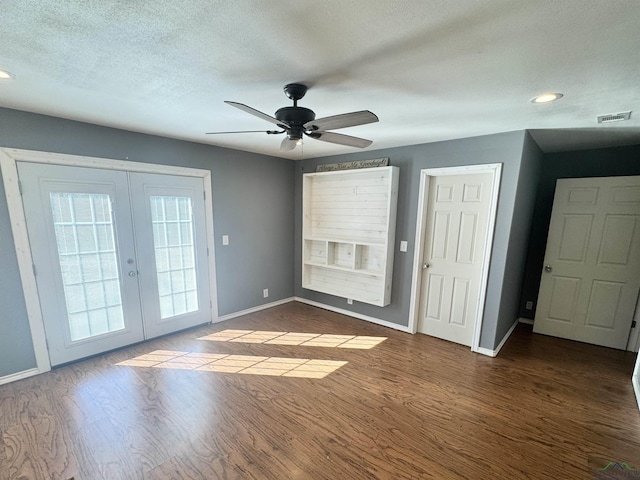 interior space with ceiling fan, a textured ceiling, dark hardwood / wood-style flooring, and french doors