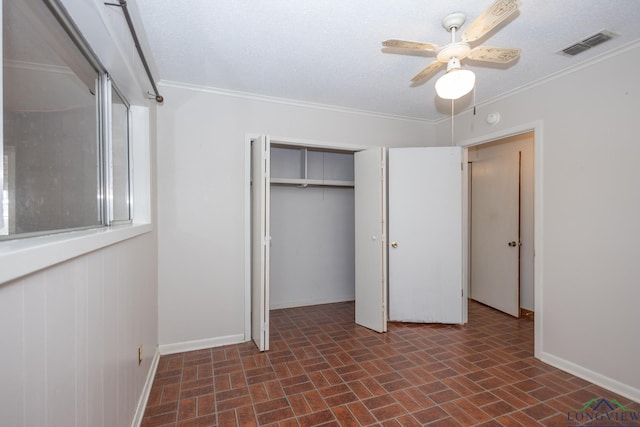 unfurnished bedroom featuring crown molding, a textured ceiling, ceiling fan, and a closet