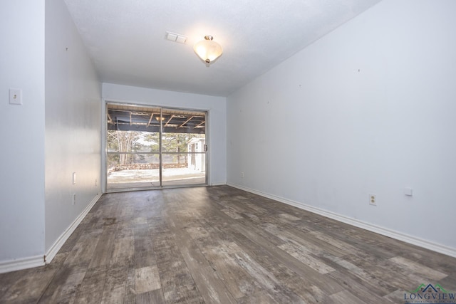 spare room featuring dark wood-type flooring