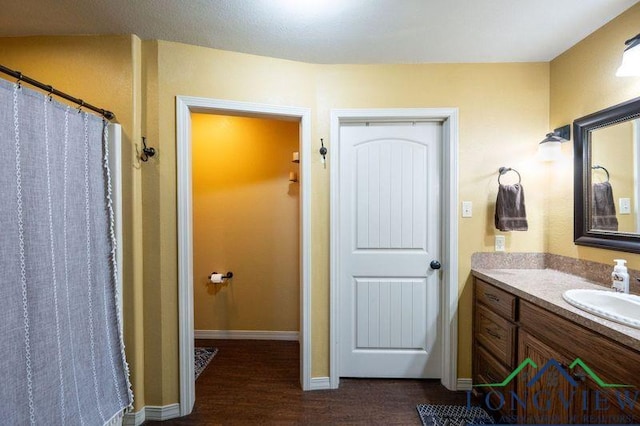 bathroom with a shower with curtain, hardwood / wood-style flooring, and vanity