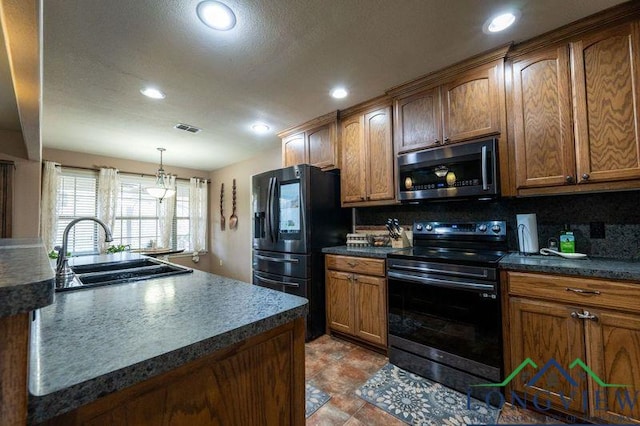 kitchen featuring sink, tasteful backsplash, hanging light fixtures, and black appliances