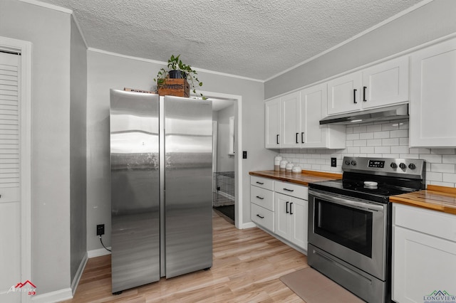 kitchen with light wood-type flooring, appliances with stainless steel finishes, butcher block countertops, and under cabinet range hood