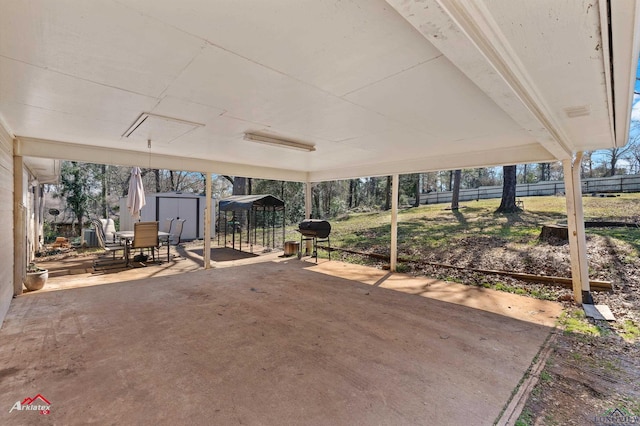 view of patio / terrace featuring an outdoor structure, fence, and a shed