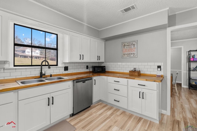 kitchen featuring butcher block countertops, visible vents, dishwasher, and a sink