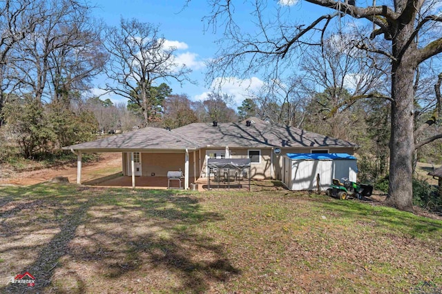 rear view of house with a yard and a patio