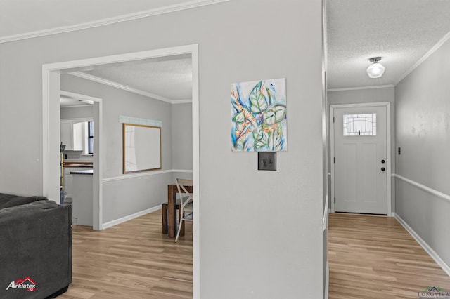 entrance foyer with a textured ceiling, light wood-type flooring, baseboards, and crown molding