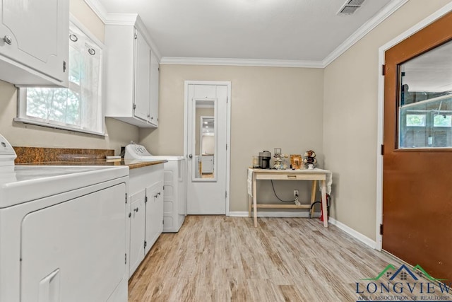 washroom featuring visible vents, ornamental molding, washing machine and dryer, cabinet space, and light wood finished floors